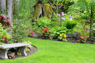 A person sitting on a bench in a garden Description automatically generated
